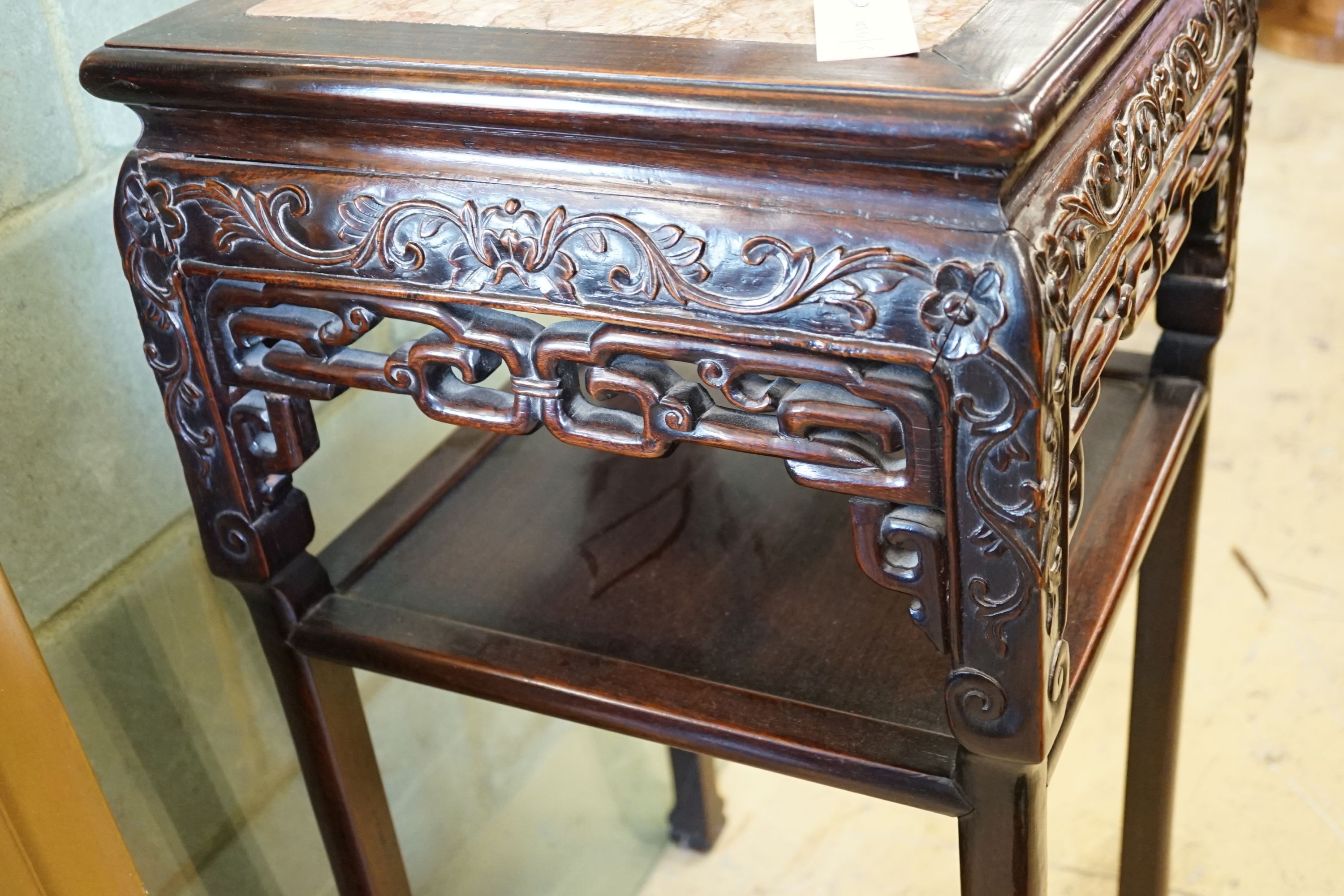 A Chinese carved hardwood rouge marble topped two tier vase stand, width 41cm, height 81cm